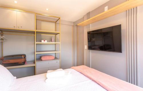 1 dormitorio con 1 cama y TV en la pared en FS Confort - Flat Residence Mar, en João Pessoa