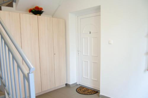 a hallway with a white door and a staircase at Bodó apartman 2 in Hévíz