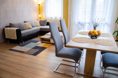 een woonkamer met een tafel en een bank bij Bodó apartman 2 in Hévíz