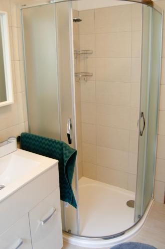 a shower with a glass door in a bathroom at Bodó apartman 2 in Hévíz