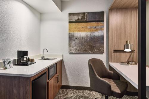 Habitación de hotel con lavabo y silla en SpringHill Suites Phoenix Tempe Airport en Tempe
