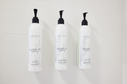 a group of three white shampoo bottles on a white background at SpringHill Suites Phoenix Tempe Airport in Tempe