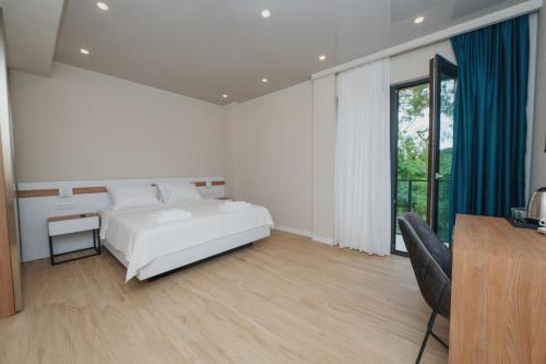 una camera bianca con un letto e una sedia di Ritsa Resort a Ureki