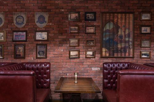 a bar with leather chairs and a brick wall at Sheraton Grand Doha Resort & Convention Hotel in Doha