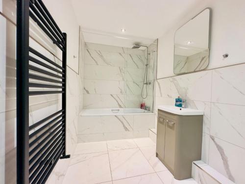 y baño con bañera, lavabo y espejo. en Super Central One Bedroom Flat Next To Brighton Beach, en Brighton & Hove