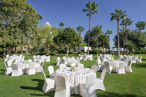 a group of white tables and chairs in a field at Sheraton Grand Doha Resort & Convention Hotel in Doha