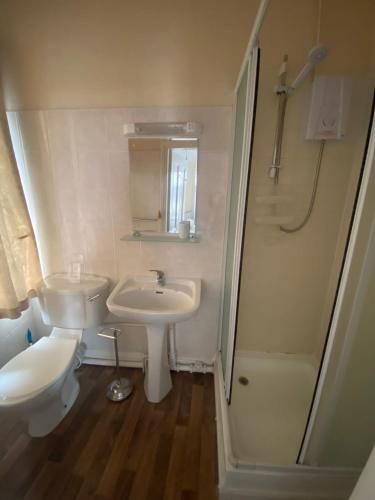 a bathroom with a sink and a toilet and a shower at Victoria Guest House in Stoke on Trent