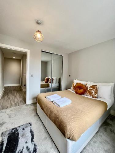 a bedroom with a large bed and a mirror at Deluxe 2 Bed 2 Bath Flat - Windsor, Heathrow Airport, Slough Station in Slough