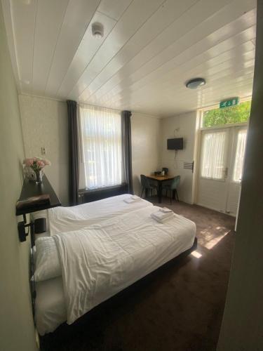 a bedroom with a bed and a table in it at Het Wapen van Aelden in Aalden