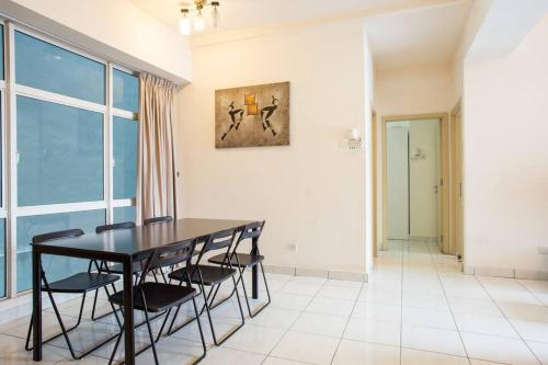 a dining room with a black table and chairs at Cosy 2Bed2Bathroom at Casa Suites in Petaling Jaya