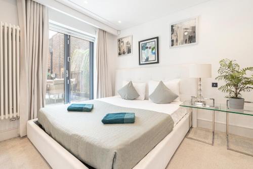 1 dormitorio con cama y mesa de cristal en Stay Picadilly en Londres