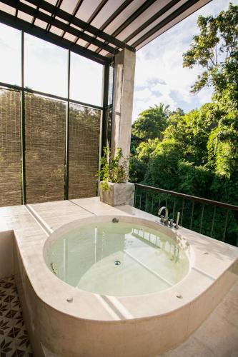 a jacuzzi tub in a room with windows at Proud Phu Fah Maerim Resort in Mae Rim