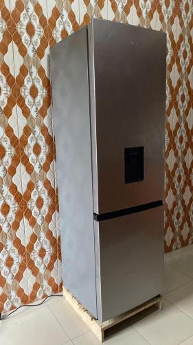 a stainless steel refrigerator sitting against a wall at Home Feeling Kilimanjaro in Moshi