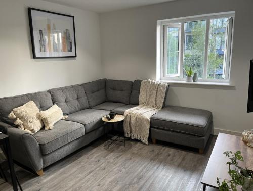 a living room with a gray couch and a chair at Regency Apartment in Hemel Hempstead