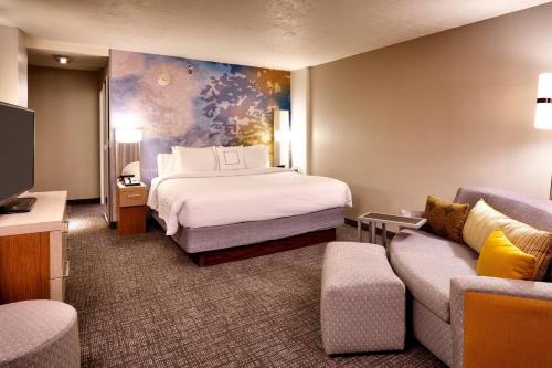 a hotel room with a bed and a couch at Courtyard by Marriott Ogden in Ogden