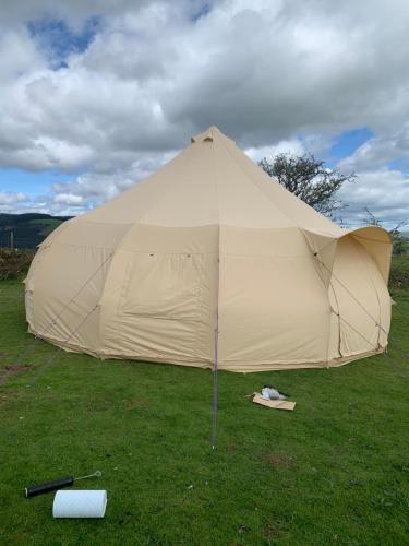 布里真德的住宿－Tal-y-fan farm (7m luna tent)，坐在草地上的大型帐篷