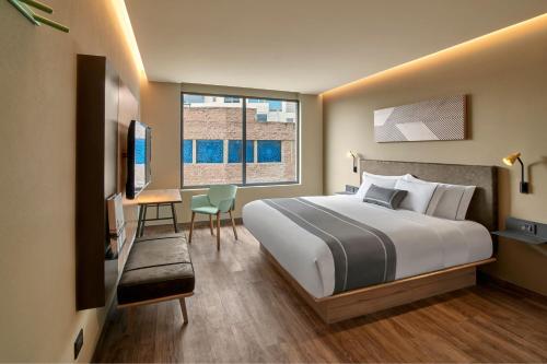 Habitación de hotel con cama grande y escritorio. en City Express Plus by Marriott Interlomas, en Ciudad de México