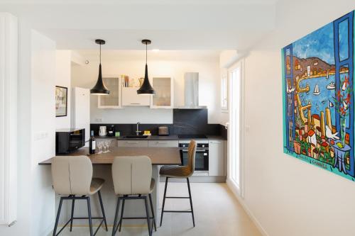 une cuisine avec une table et des chaises dans une pièce dans l'établissement Wam YourHostHelper, à Cannes