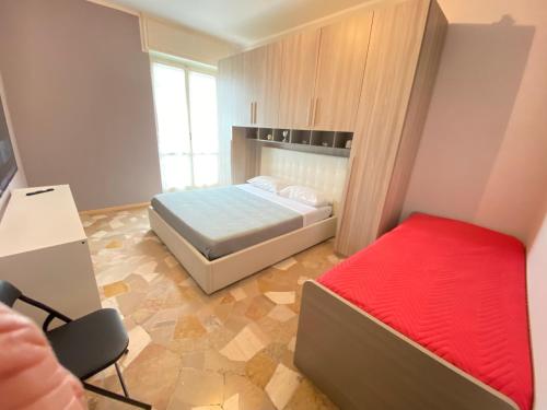 a small bedroom with a bed and a red mattress at Milano relax family house in Brugherio
