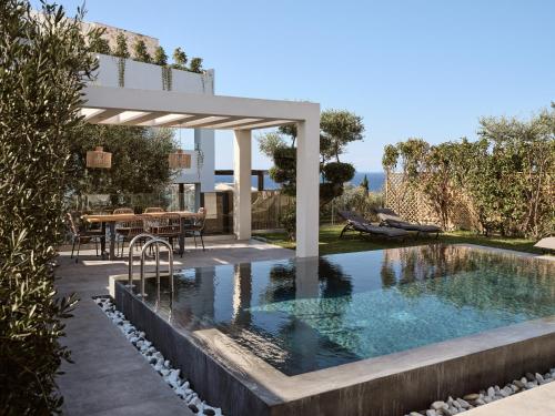 a swimming pool with a pergola next to a house at Galena Verde Luxury Villas, By ThinkVilla in Akrotiri