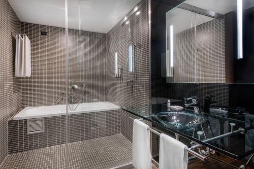 a bathroom with a sink and a glass shower at AC Hotel Brescia by Marriott in Brescia