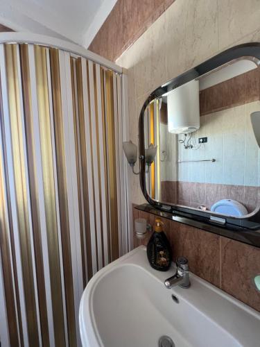 a bathroom with a sink and a mirror at Apartament Qender in Elbasan