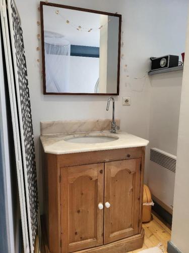 une salle de bain avec un lavabo et un miroir dans l'établissement Atypique Chapelle aménagée, à Albigny-sur-Saone