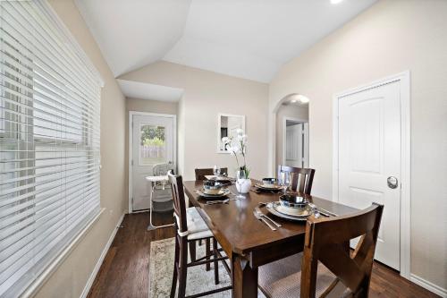 a dining room with a wooden table and chairs at Cozy Getaway Nr Airport WiFi BBQ Yard Pet in Humble