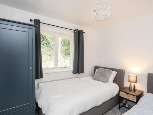 1 dormitorio con 2 camas y ventana en 39 Alwen Drive, en Rhôs-on-Sea