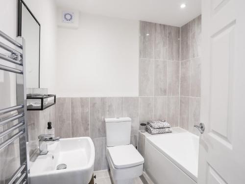 uma casa de banho com um WC branco e um lavatório. em 39 Alwen Drive em Rhôs-on-Sea