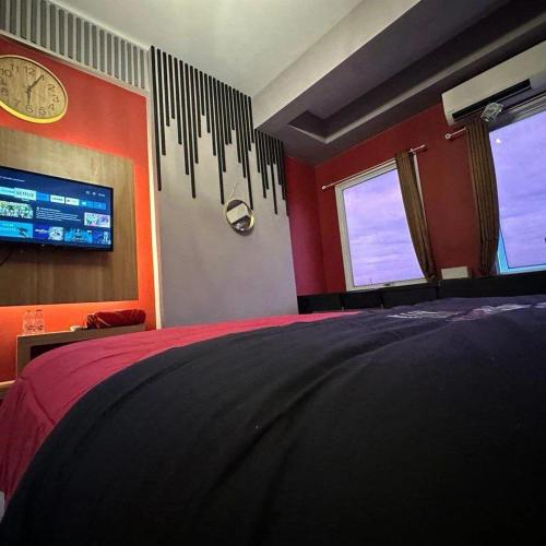 a bedroom with a bed and a clock on the wall at Patraland Urbano by Red Promo in Bekasi