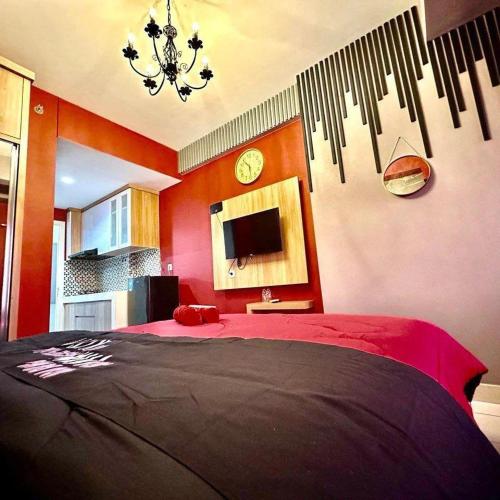 a bedroom with a large bed and a clock on the wall at Patraland Urbano by Red Promo in Bekasi