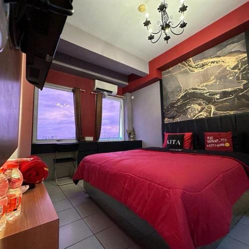 1 dormitorio con 1 cama grande de color rojo y lámpara de araña en Patraland Urbano by Red Promo, en Bekasi