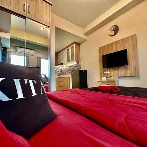 a large red bed in a room with a tv at Patraland Urbano by Red Promo in Bekasi