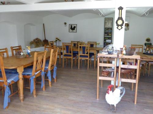 a chicken standing in the middle of a dining room at Spreewaldpension Beesk in Raddusch
