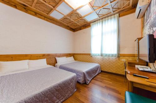 關山的住宿－東籬房民宿，酒店客房设有两张床和电视。