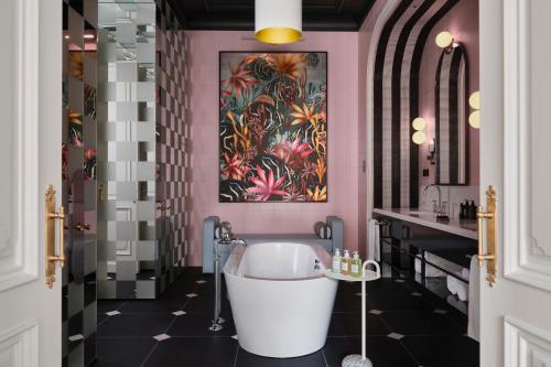 a bathroom with a tub and a pink wall at W Budapest in Budapest