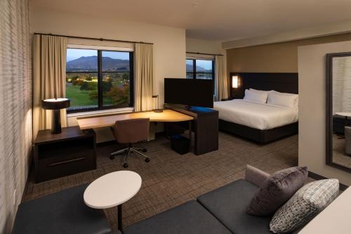 a hotel room with a bed and a desk with a computer at Residence Inn by Marriott Wenatchee in Wenatchee
