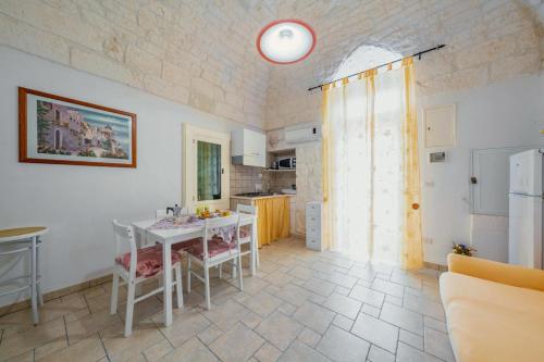 a kitchen and dining room with a table and chairs at Salentina by Rentbeat in Ostuni