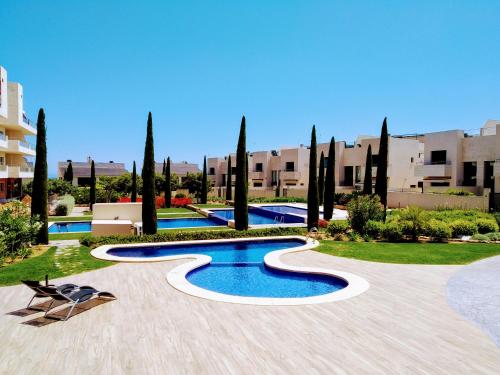 een resort met een zwembad en bomen en gebouwen bij Apartamento con solarium en Jardines de Montesolana in Alicante