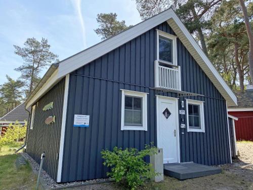 a blue building with a white door and a window at Ferienhaus Sandkörnchen - Strandpark - ca. 80m Strand in Baabe