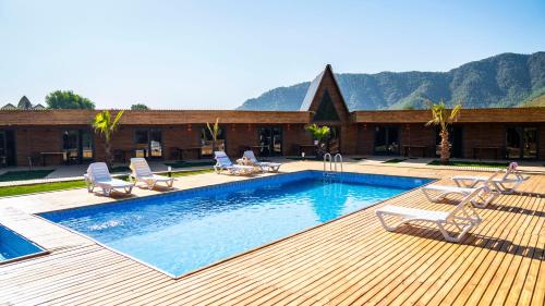 - une piscine avec des chaises et une maison dans l'établissement Araz Wooden Concept, à Kumluca