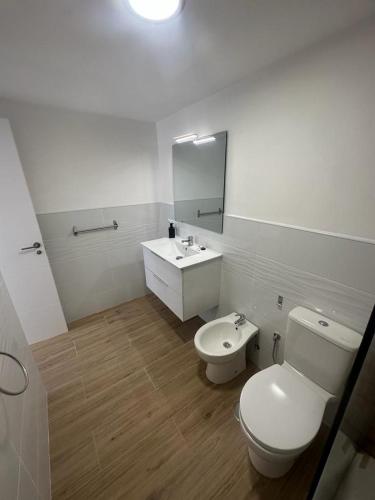 a bathroom with a toilet and a sink and a mirror at Antonio Apartment in Los Cristianos