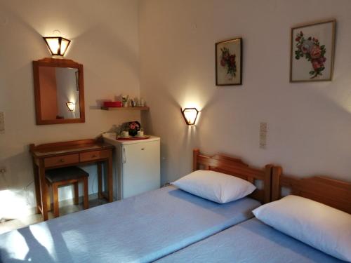 1 Schlafzimmer mit 2 Betten, einem Waschbecken und einem Spiegel in der Unterkunft Villa Mary Galini in Ireo
