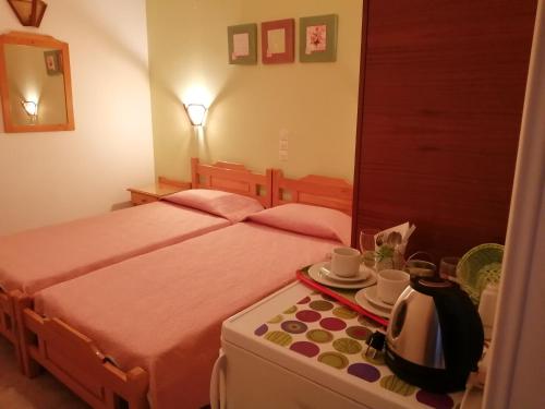 1 Schlafzimmer mit 2 Betten und einem Tisch mit einem Wasserkocher in der Unterkunft Villa Mary Galini in Ireo