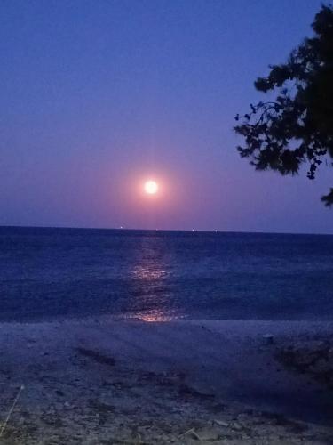 Ein Vollmond, der nachts über dem Ozean aufgeht in der Unterkunft Villa Mary Galini in Ireo