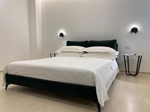 a bedroom with a large bed with white sheets and pillows at Dimora Zonno in Bari