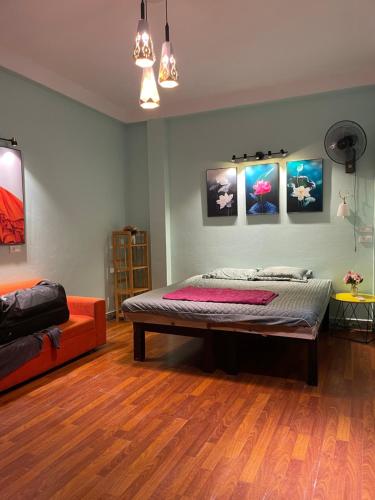 a bedroom with a bed and paintings on the wall at Cozy Homestay in Hanoi