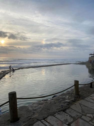 a man standing in a pool of water next to the ocean at Azenhas do Mar Cottage in Sintra