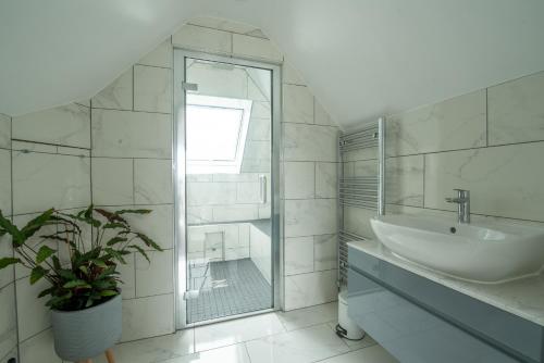 a white bathroom with a sink and a mirror at Maycliffe in Shanklin